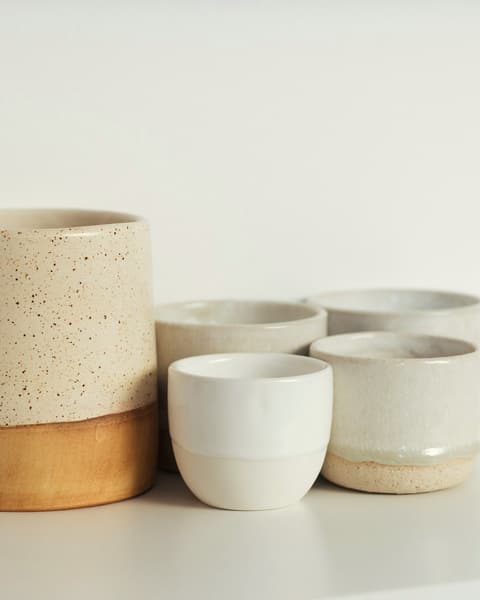 Stoneware cups with a sand-coloured base and white rim
