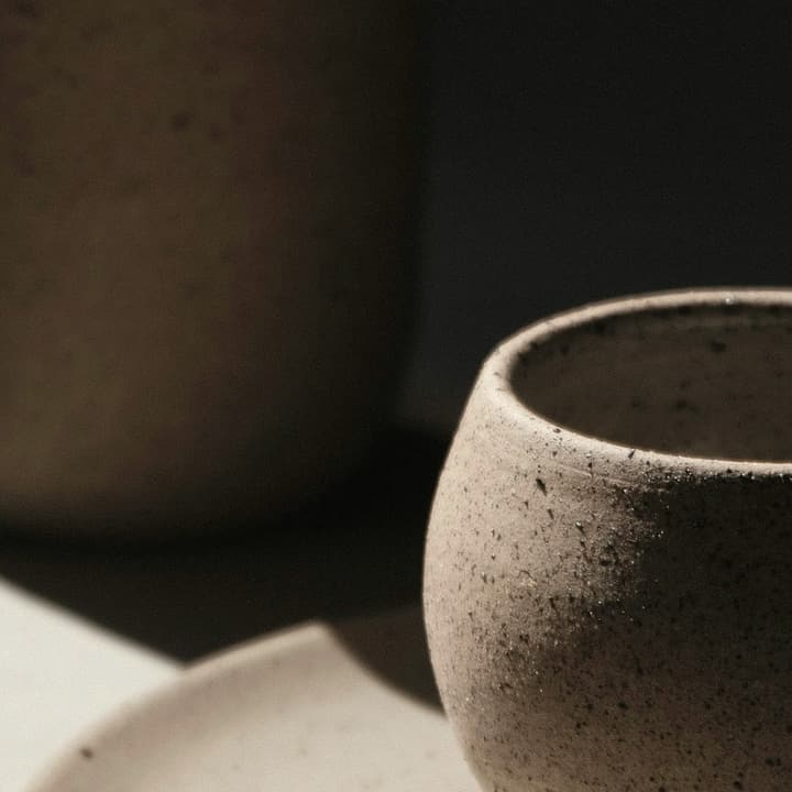 Dark moss-green jug and cup on a matching plate, detail of the glaze
