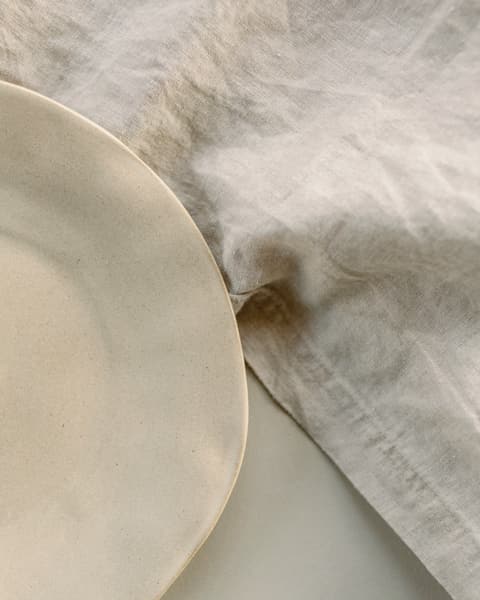 A white stoneware plate on a linen cloth
