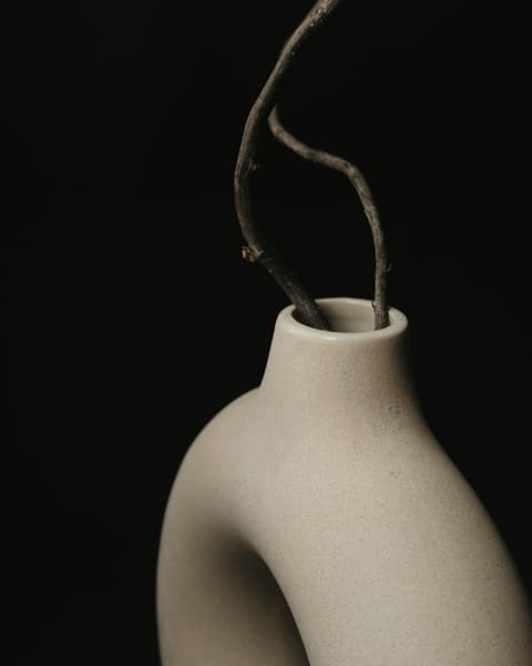 Close-up of a pale oat stoneware vase with a ridged surface