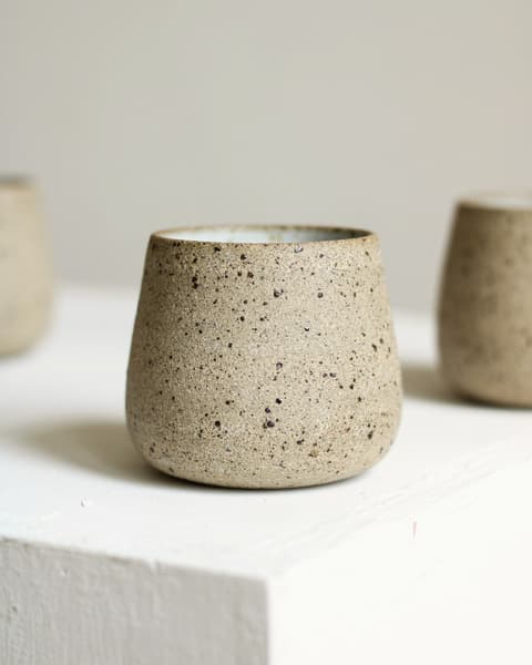 Speckled oat tumbler on a white plinth